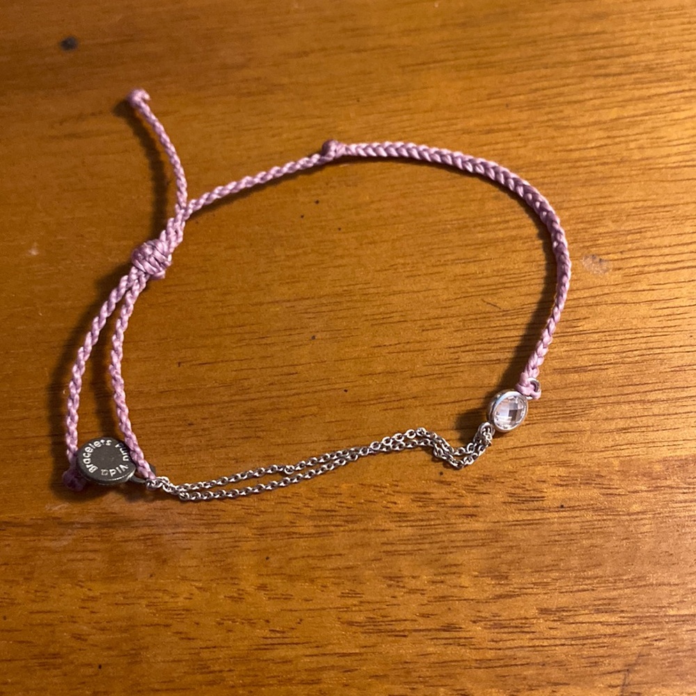 Lavender colored bracelet with gem in the middle then half chain